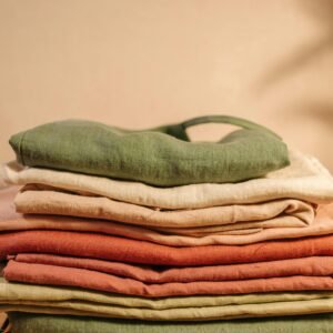 Vertical shot of neatly folded colorful linen fabrics in earthy tones for textile design.